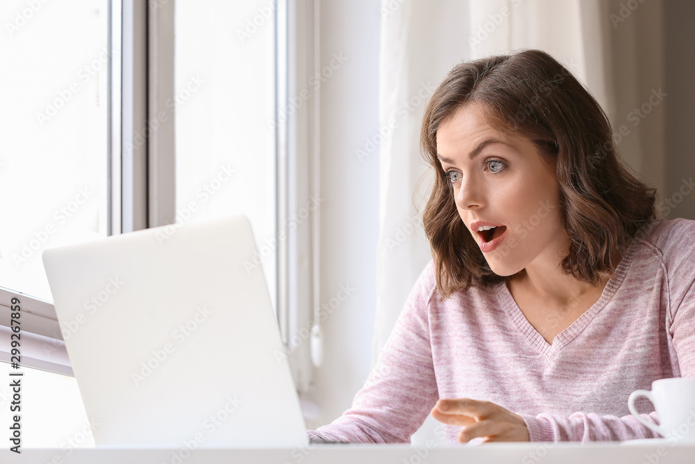 Surprised young woman with laptop at home Surprised young woman with laptop at home