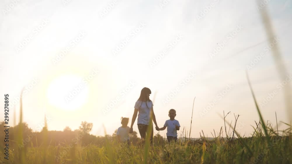 happy family funny walking go for are hold hands a teamwork Silhouette. happy little children boy and girl with mother family at sunset. mom and son mom lifestyle daughter and son in white t-shirts