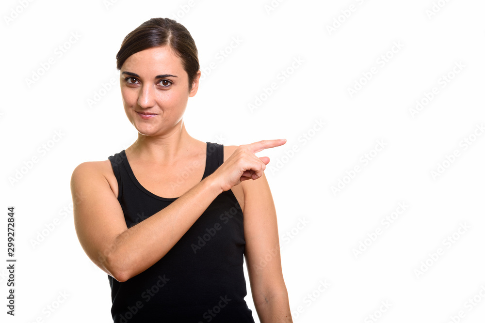 Studio shot of beautiful woman pointing finger at side