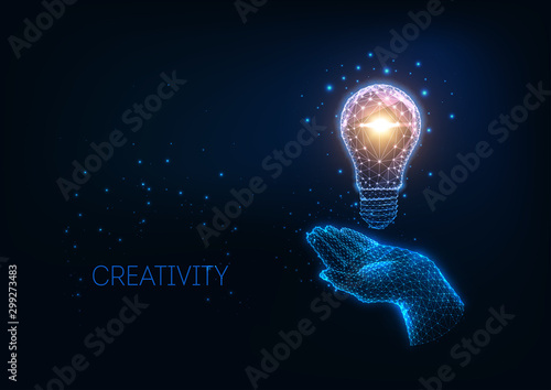 Futuristic idea, creativity concept with glowing low polygonal light bulb and human hand.