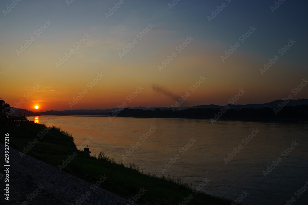 sunset over the mountains and river background
