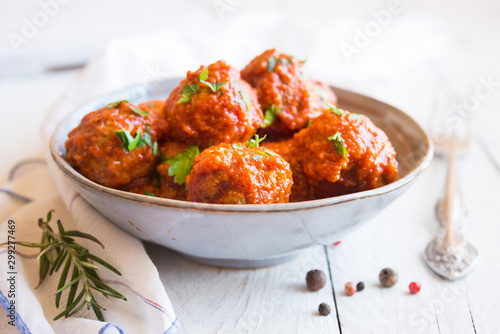 Homemade meatballs with tomato sauce and parsley in a bowl photo