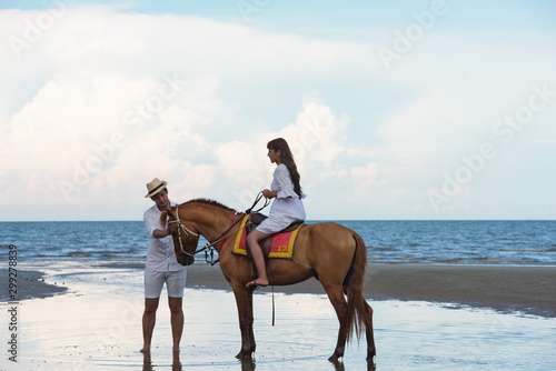 Couples are happily riding horses on the sandy beach