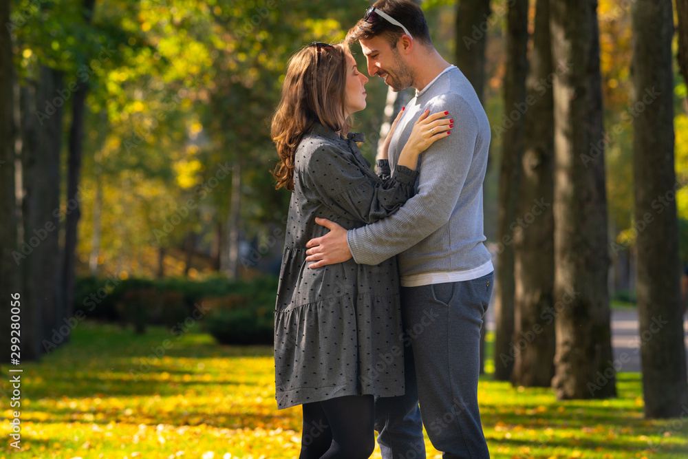 Young pregnant woman hugging her husband Young pregnant woman hugging her husband