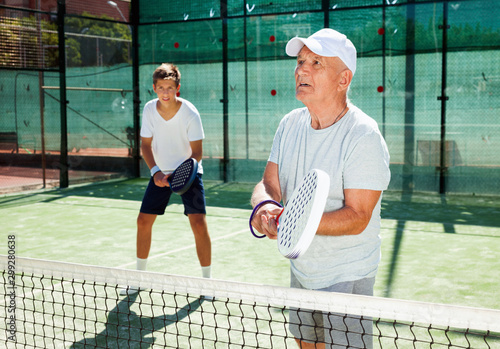 padel players of different generations playing padel court