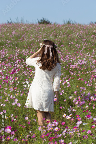 Asian woman with cosmos flower field