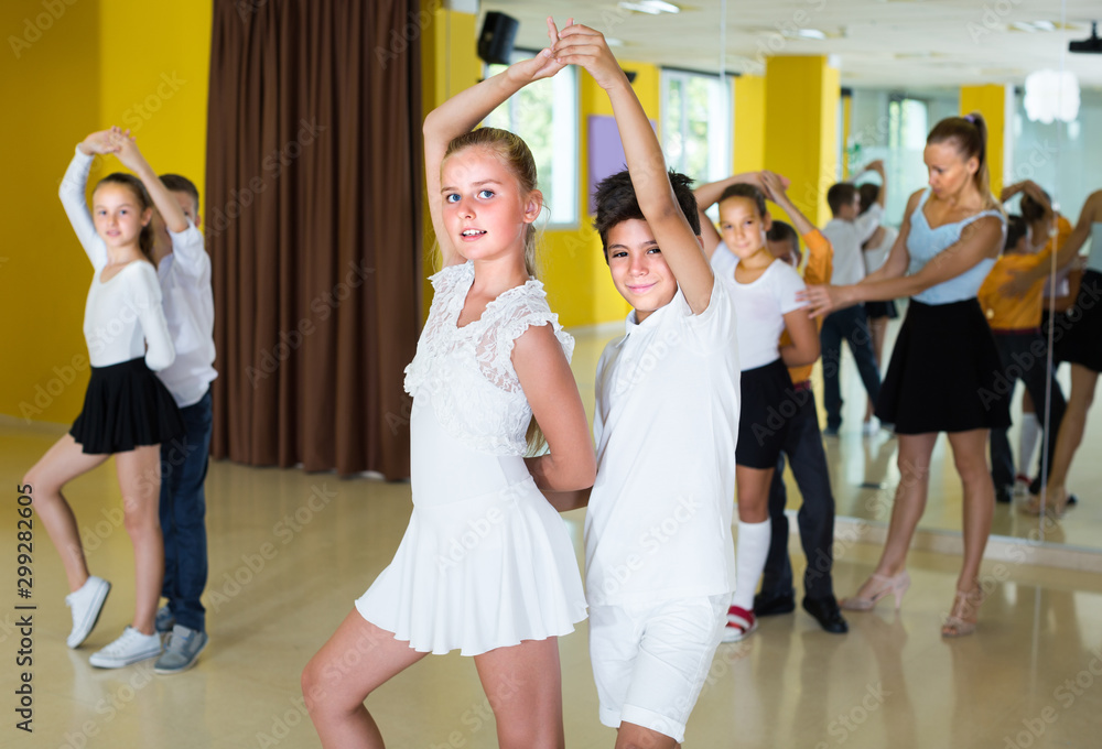 Positive kids are dancing rock-n-roll in pairs