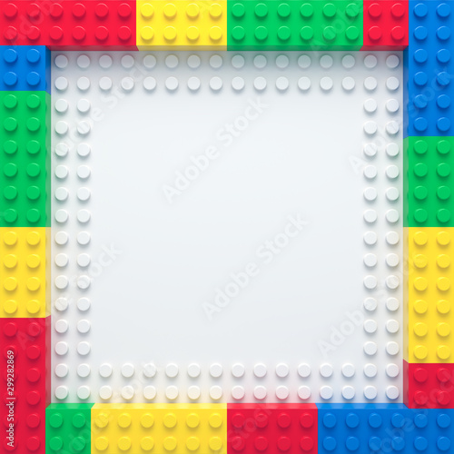 Frame of colorful toy bricks on white construction plate