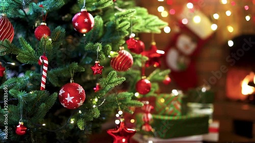 Christmas Tree with Decorations Near a Fireplace with Lights