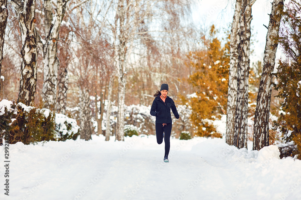Runner girl jogging in on nature in winter