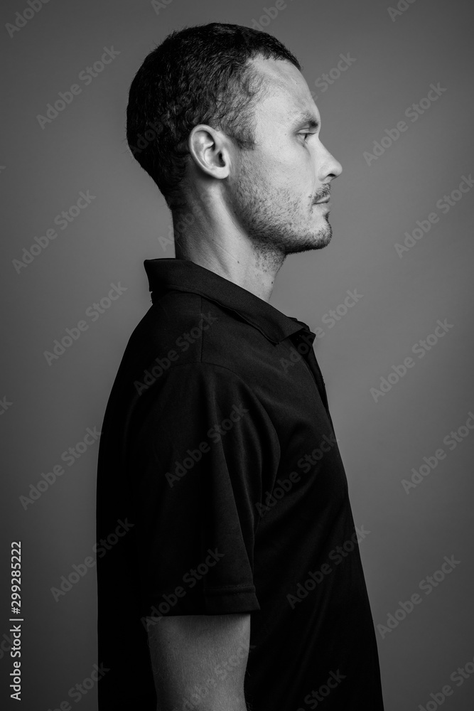 Handsome man against gray background in black and white Handsome man against gray background in black and white
