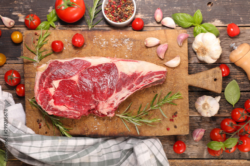 raw beef chop with ingredient on wooden background, rib of beef