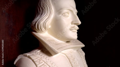 A slow motion close POV forward dolly shot of a Shakespeare bust on display in a wooden cabinet. photo