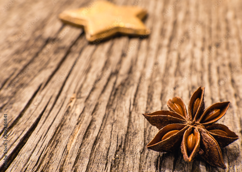 Christmas decoration macro: Star anise and golden star on rustic wooden background, retro style Christmas decoration macro: Star anise and golden star on rustic wooden background, retro style