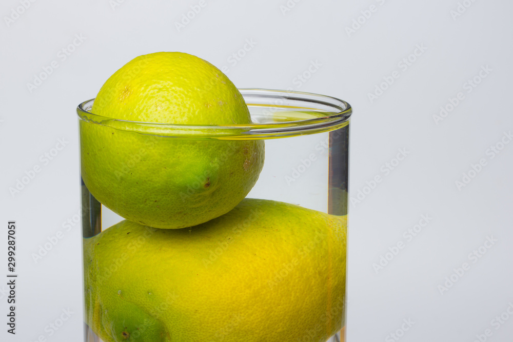 Limones en agua, dentro de un jarrón lleno de agua, jarrón o recipiente  transparentye. foto de Stock | Adobe Stock
