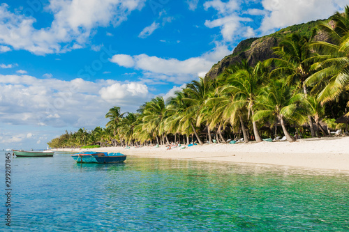 Tropical view of the resort on Mauritius. Ocean with boat, sandy beach with palms photo