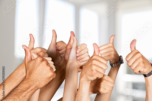 Group of people hands showing thumbs up signs on background