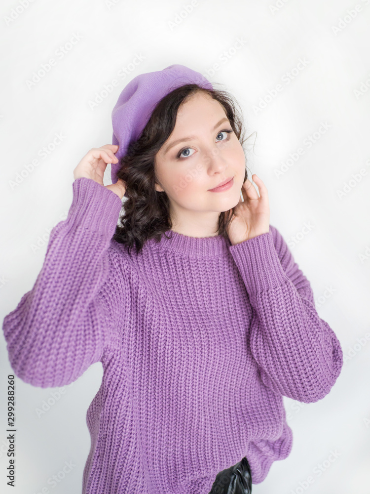 Closeup portrait of a beautiful girl in a lilac headdress smiling looking at the camera on a white background close-up Closeup portrait of a beautiful girl in a lilac headdress smiling looking at the camera on a white background close-up