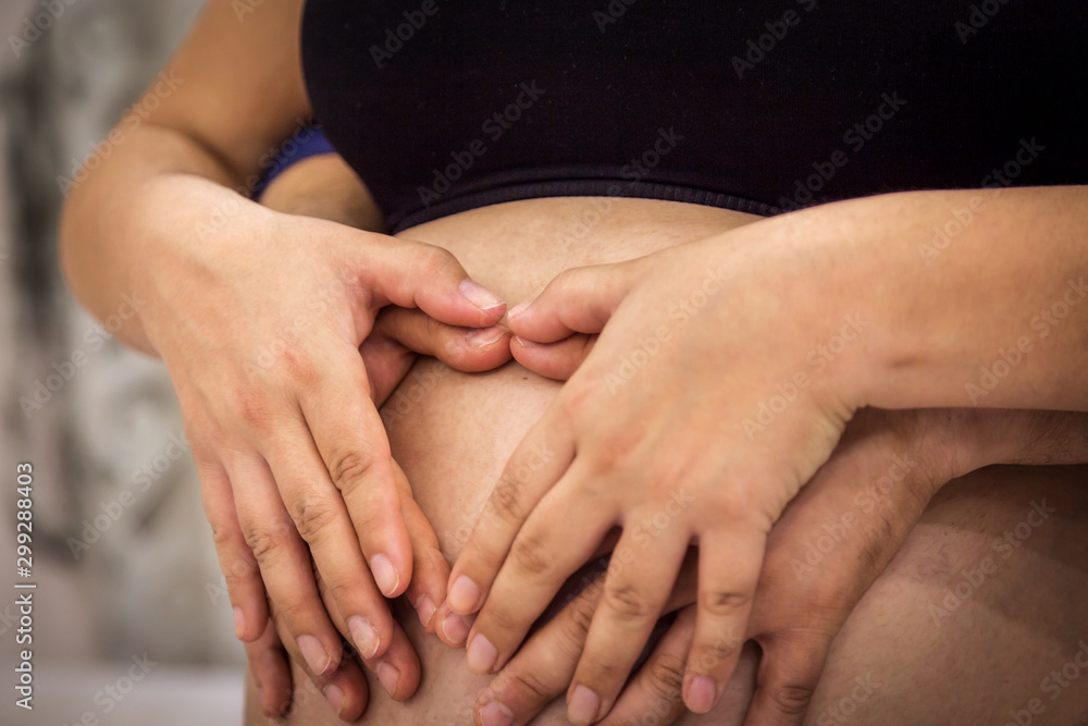 Pregnancy girl. Mom and Dad with hands on the belly of a pregnant girl, Heart of hands by couple on pregnant belly Pregnancy girl. Mom and Dad with hands on the belly of a pregnant girl, Heart of hands by couple on pregnant belly