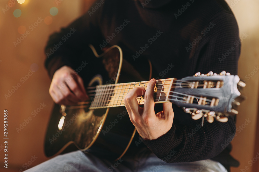 Fototapeta premium the guy plays the guitar. close-up of hands