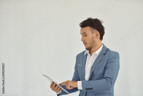 Young business man in a suit is playing a tablet