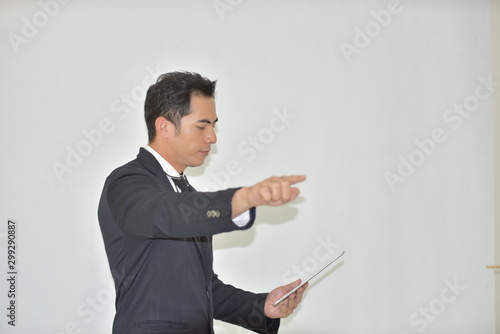 Young business man in a suit is playing a tablet