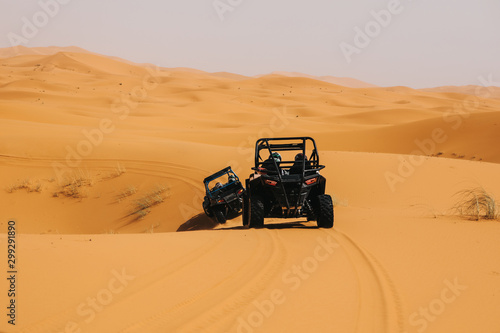Off road buggies crossing dunes in the desert. Rally raid adventure.