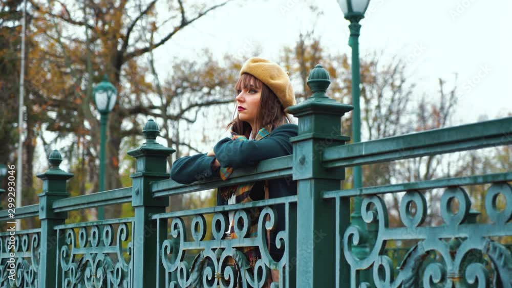 Depressed girl standing on bridge in park Depressed girl standing on bridge in park