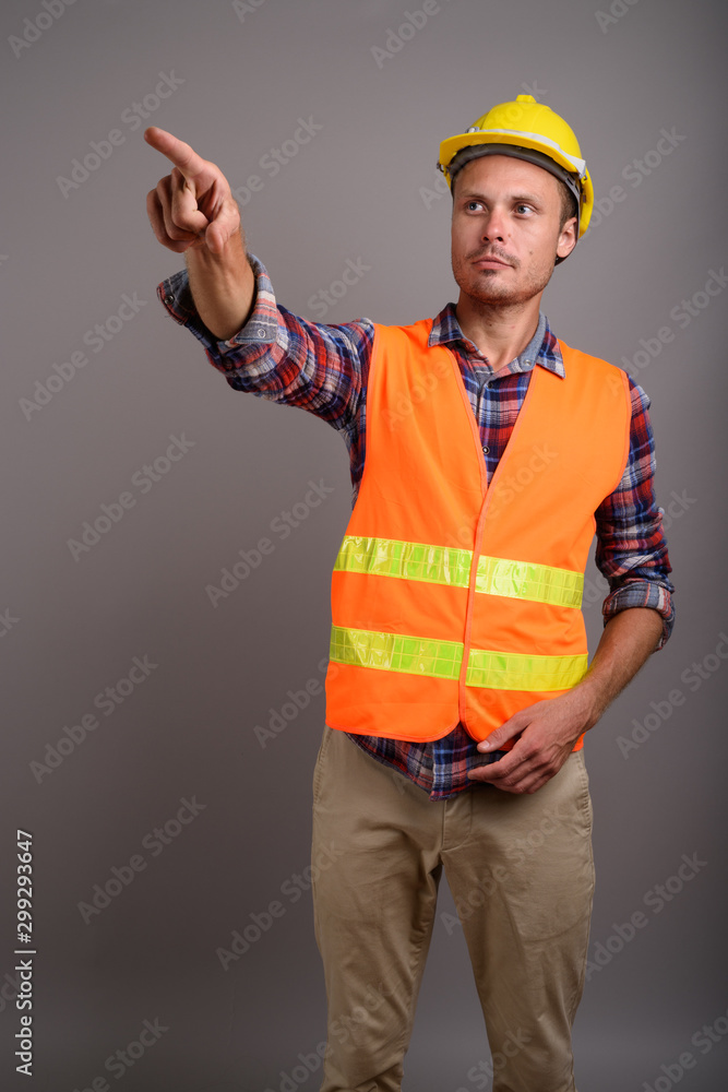 Portrait of handsome man construction worker against gray background Portrait of handsome man construction worker against gray background