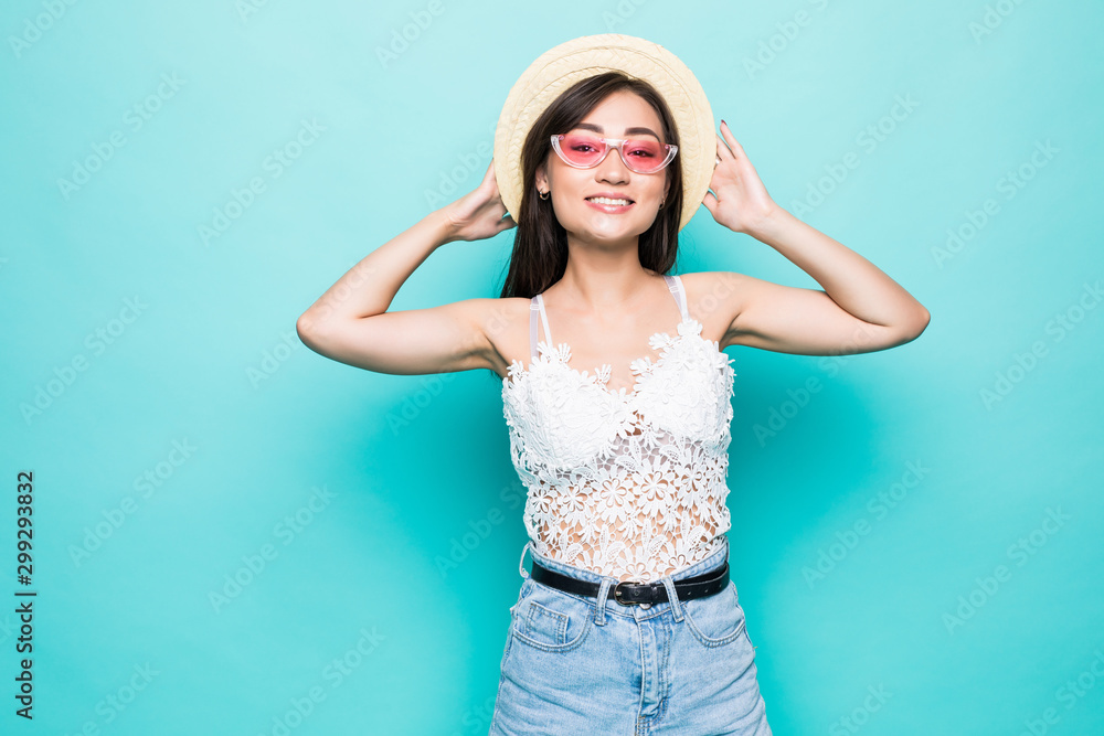Young asian woman with sunglasses and straw hat standing isolated on green background Young asian woman with sunglasses and straw hat standing isolated on green background
