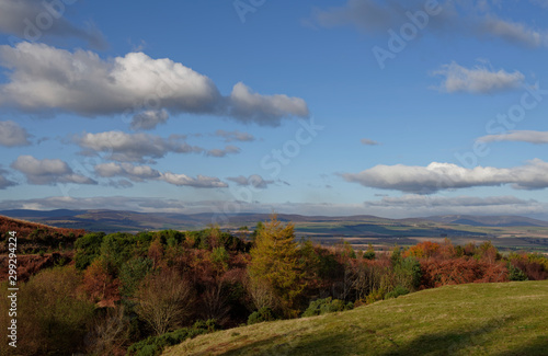 The view north from Finavon Hill towards the Angus Glens on a bright clear day, with the tree foliage beginning to display its Fall colours.