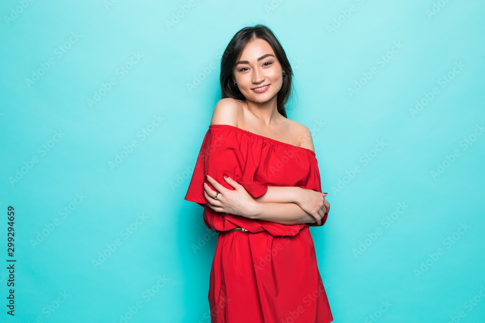 Attractive young asian woman in red dress isolated on green background Attractive young asian woman in red dress isolated on green background