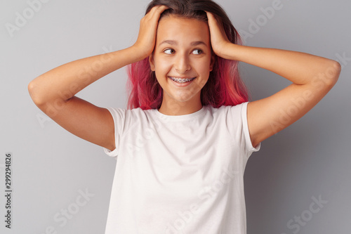 Young teen girl portrait being excited and amazed over gray background © fotofabrika