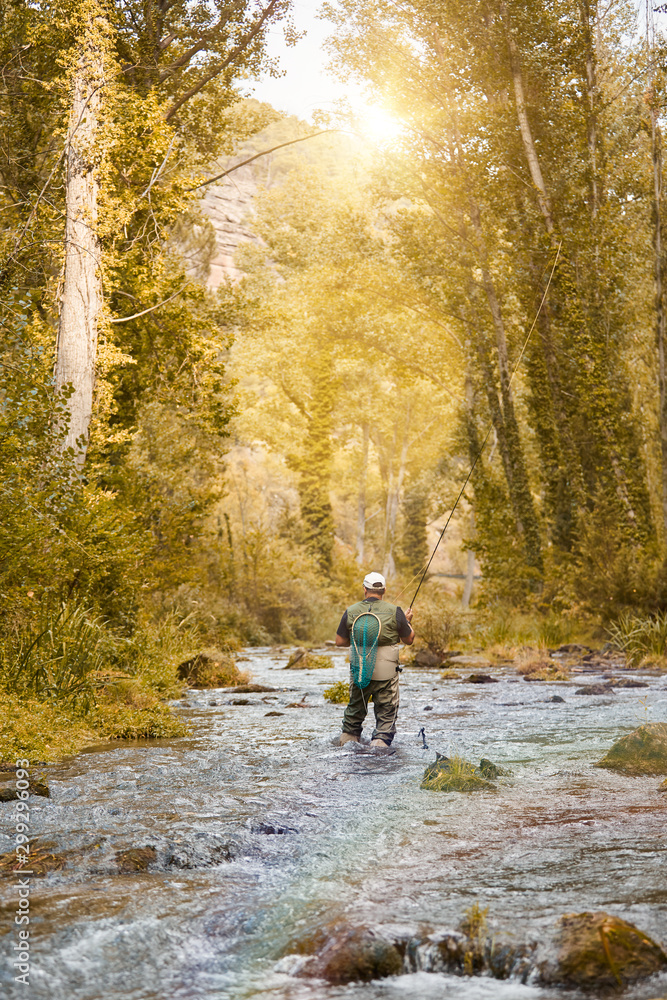 Obraz premium Man fishing a river