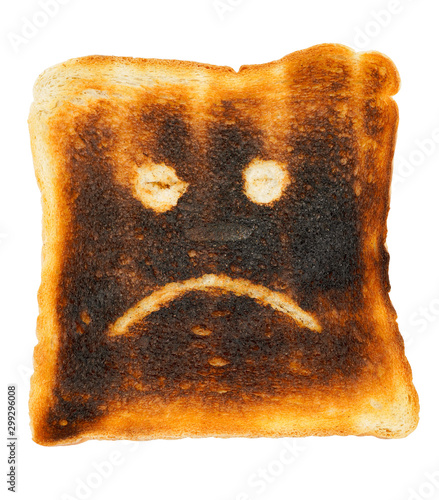 Unhappy smiley burnt slice of toast bread. Signs symbol mad mood on slice of roasted bread. P