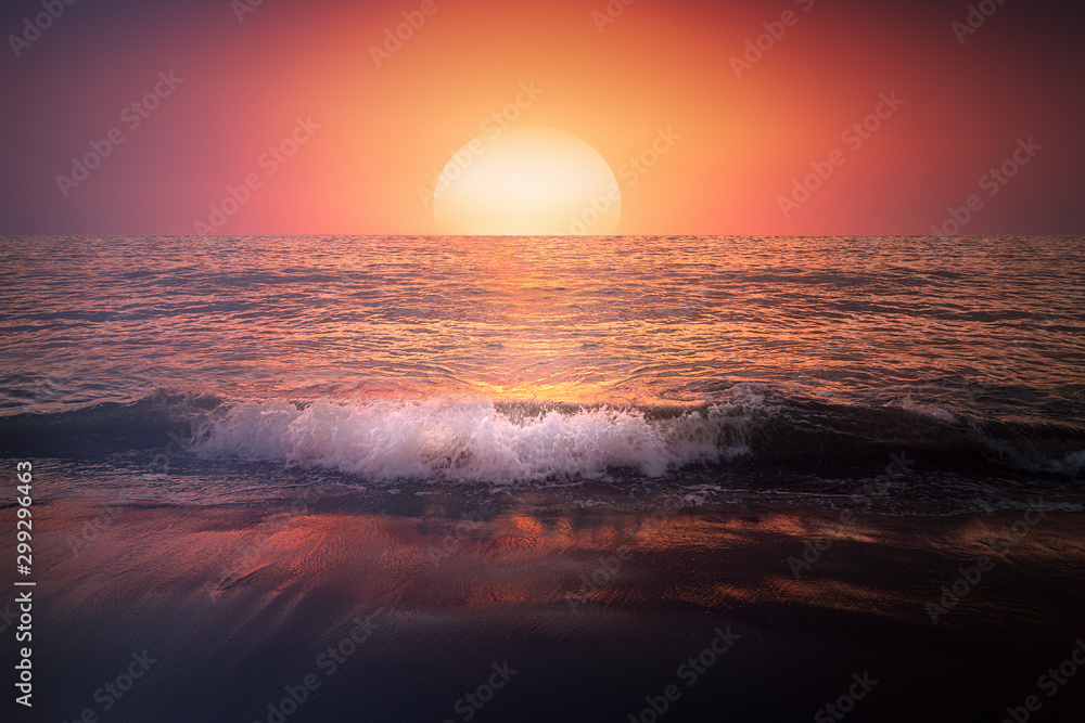 red sunset on beach with a wave on the shore and big sun