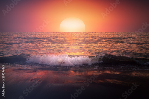 red sunset on beach with a wave on the shore and big sun © mimadeo
