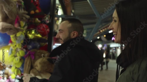 coppia al luna park con maschio che gioca al tiro a segno e femmina che fuma photo