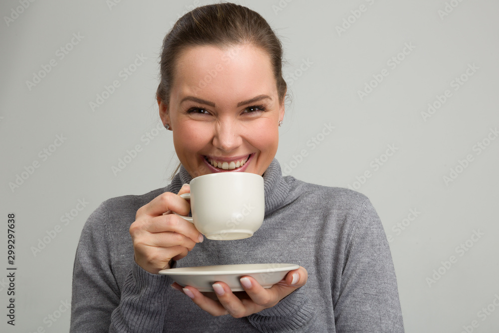 Young beautiful woman with a cup of fresh coffee or tea in her hand Young beautiful woman with a cup of fresh coffee or tea in her hand