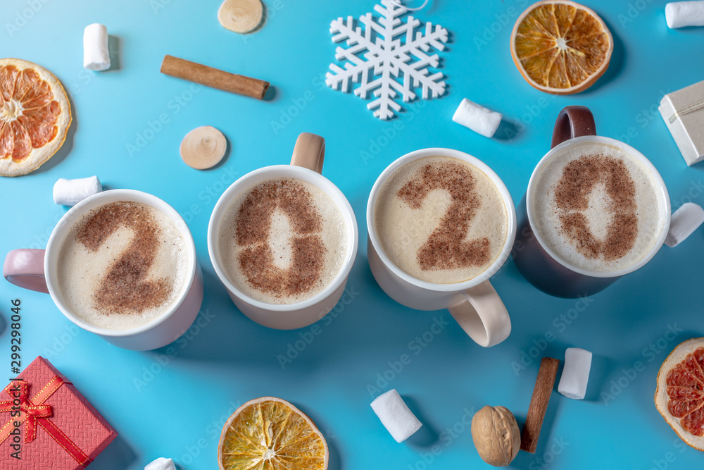 Card with numbers 2020 for New year and Christmas. Cup of coffee with figures on blue background. Top view. Flat lay Card with numbers 2020 for New year and Christmas. Cup of coffee with figures on blue background. Top view. Flat lay