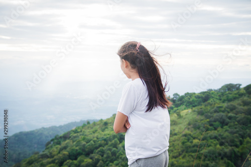 rear of happy woman stand on top mountain looking view with mist and cloud. soft focus and noise.