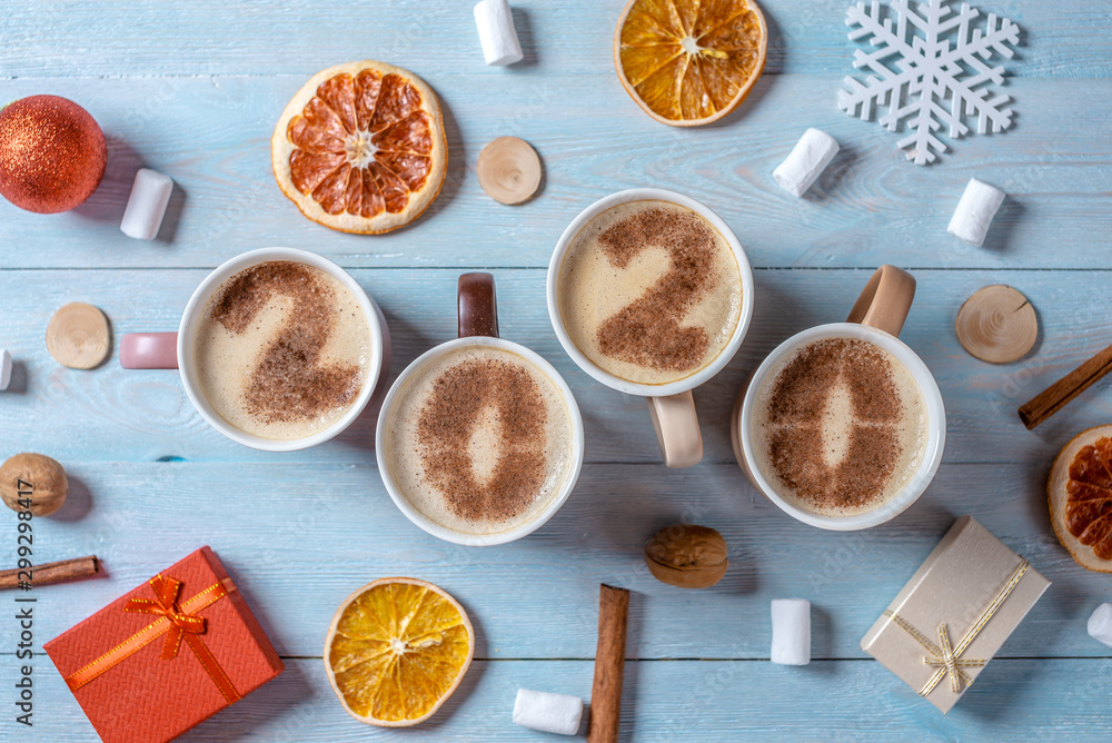 Card with numbers 2020 for New year and Christmas. Cup of coffee with figures on blue wooden background. Top view Card with numbers 2020 for New year and Christmas. Cup of coffee with figures on blue wooden background. Top view