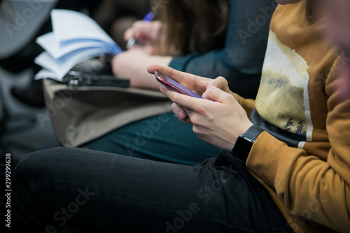 Students Using Smartphones During the Lecture. Young People Using Social Media while Studying in the University.
