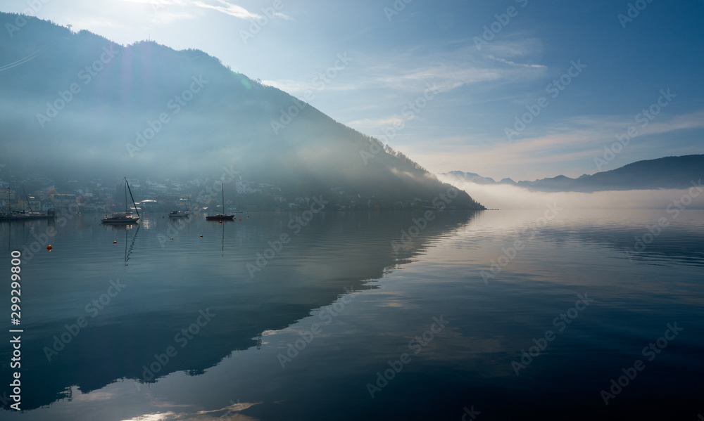 Backlit view of boats anchored at the Traunsee in Gmunden, OÖ, Austria with the Grünberg rising in the background