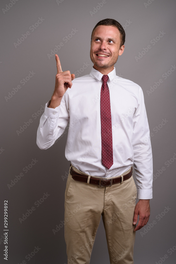 Portrait of handsome businessman against gray background