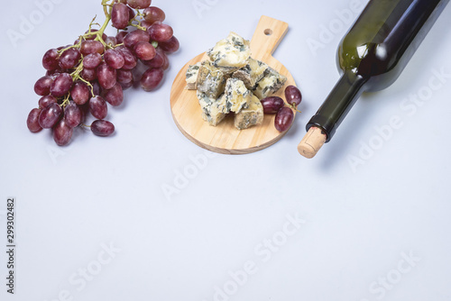 Bottle of Red Wine Cheeses and Pink Grapes on Blue Background Top View Flat Lay Copy Space