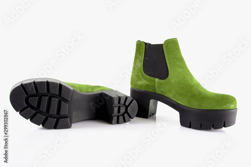 Pair of female green leather boots on white background, isolated product, top view.