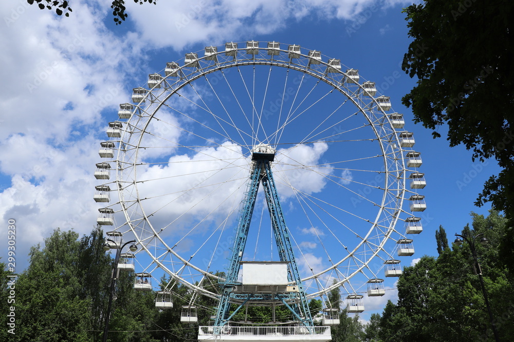 Big Ferris wheel in the Park with background of summer blue sky and clouds