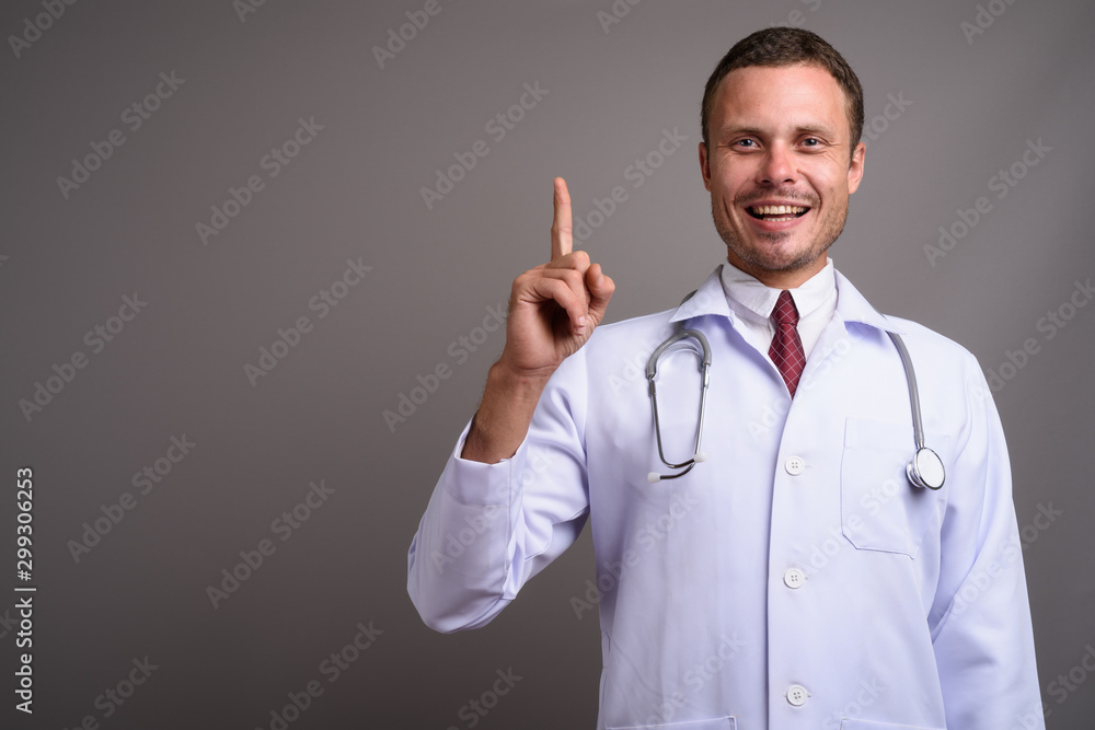 Portrait of handsome man doctor against gray background Portrait of handsome man doctor against gray background