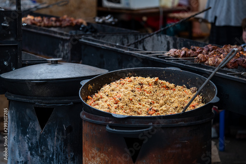 Cauldron with pilaf or pilau rice dish on street food fest 